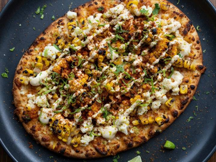 Street-corn elote pizza with charred corn, chili powder, lime and crema
